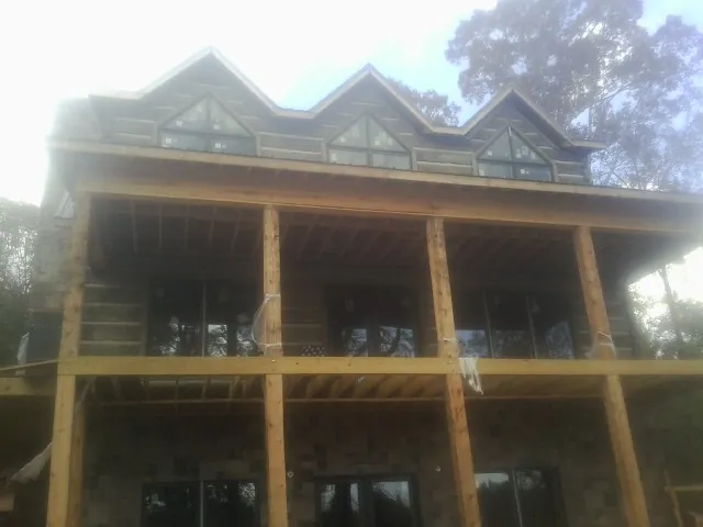 Dormers and porch framing on a large log home under construction — Roof Coating work by our crew in Melbourne